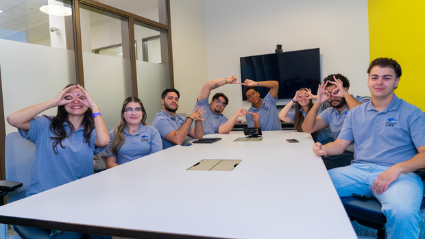 Student life members in a group sitting on a table